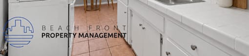 A kitchen with white cabinets and a tiled floor.