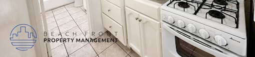 A kitchen with a stove, sink, and cabinets.