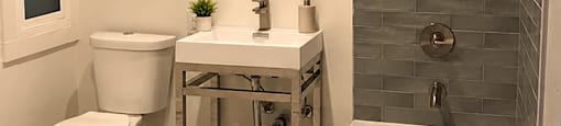 A white toilet sits next to a sink in a bathroom.