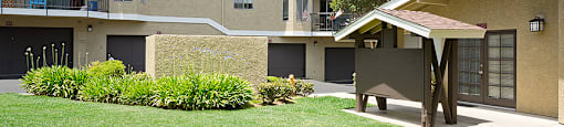 an apartment building with a yard and a picnic table