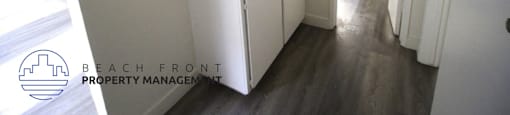 a small kitchen with white cabinets and a white refrigerator