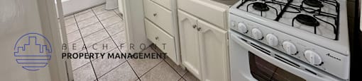 A small kitchen with a white stove and white cabinets.