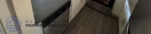 A kitchen with a stove, sink, and cabinets.