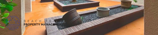 A courtyard with a fountain and potted plants.