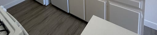 A kitchen with white cabinets and a white sink.