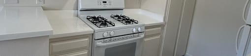 A white kitchen with a stove and oven.
