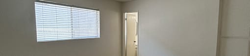 A room with a window and wooden flooring.