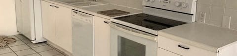 a white kitchen with a stove and a refrigerator