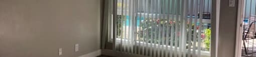 A room with a sliding glass door and wooden flooring.