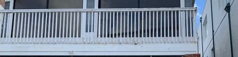 a house with a porch on top of a brick wall