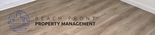 A room with a ceiling fan and a logo for Beach Front Property Management.