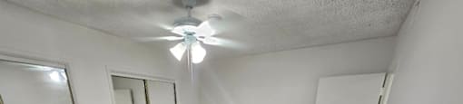 an empty bedroom with a ceiling fan