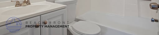 A white bathroom with a toilet, sink, and bathtub.