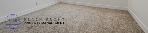 A room with a carpeted floor and a window with blinds.