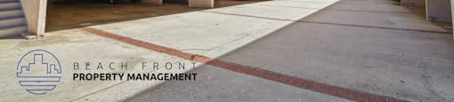 A parking garage with a clear blue sky in the background and a logo for Beach Front Property Management.