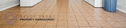 A clean, empty room with a sign that says "Beach Front Property Management".