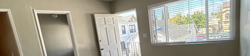 an empty living room with hardwood floors and a window