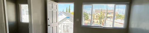 an empty living room with wood floors and a window