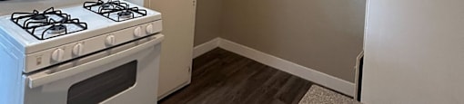 an empty kitchen with white appliances and white cabinets