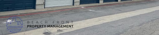 A row of garage doors with the logo of Beach Front Property Management on the bottom left.