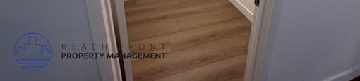 A white hallway with a logo for Beachfront Property Management.
