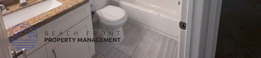 A white bathroom with a toilet, sink, and bathtub.