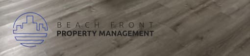 A kitchen with a counter and cabinets with a logo for Beach Front Property Management.