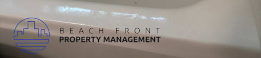 A white bathtub with a logo for Beach Front Property Management.