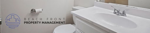 A white bathroom with a toilet, sink, and mirror.