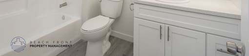 A white bathroom with a toilet, sink, and mirror.