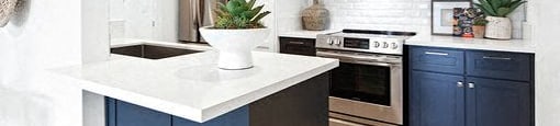 A kitchen with a white countertop and blue cabinets.