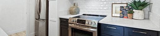 A kitchen with white cabinets and a black stove top oven.