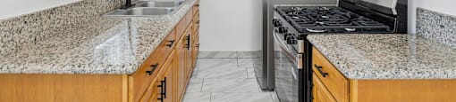 A kitchen with granite countertops and wooden cabinets.