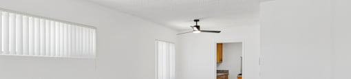 A room with a ceiling fan and wooden flooring.