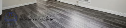 the living room of an apartment with wood flooring and a window