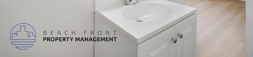A white bathroom with a sink and mirror.