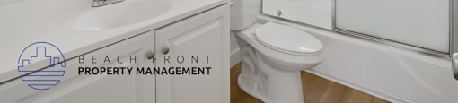 A white bathroom with a sink, toilet, and mirror.