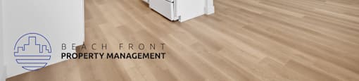 A kitchen with white appliances and wooden floors.