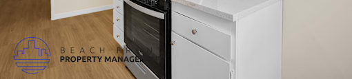 A kitchen with a stove top oven and a fan on the ceiling.