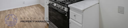 A kitchen with a stove top oven and a fan on the ceiling.