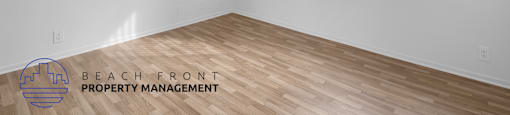 A room with wooden flooring and a window with blinds.