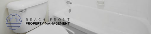 A white bathroom with a toilet, tub, and shower.