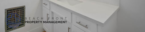 A bathroom with a white countertop and two round mirrors.