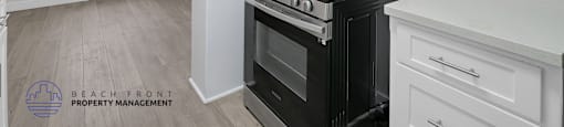 A kitchen with a black stove top oven and white cabinets.