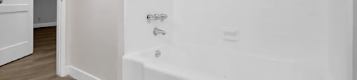 A white bathtub with a shower head and faucet in a bathroom.
