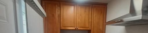 an empty kitchen with wooden cabinets and stainless steel appliances