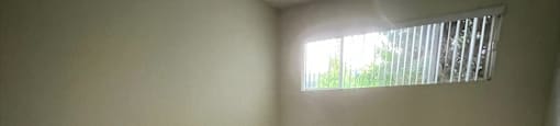 an empty room with carpet and a window