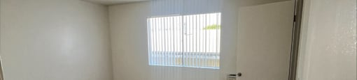 an empty room with a window and a door