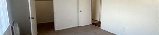 an empty living room with carpet and white walls