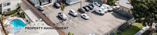 An aerial view of a property management company's office with a swimming pool and parking lot.
